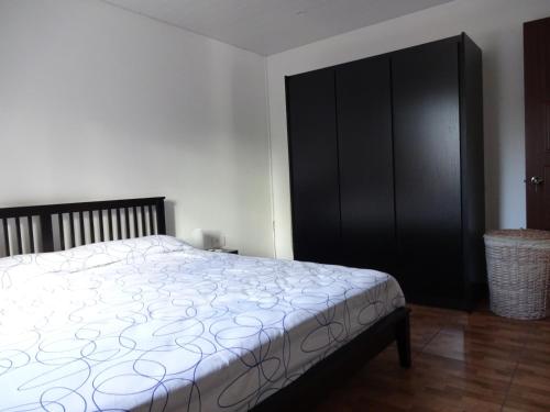 ein Schlafzimmer mit einem Bett und einem schwarzen Schrank in der Unterkunft View on Ilot Fourneau in Le Morne
