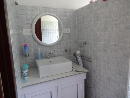 uma casa de banho com um lavatório branco e um espelho. em View on Ilot Fourneau em Le Morne