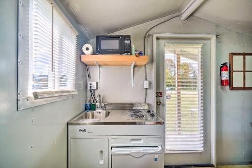una piccola cucina con lavandino e una TV su una mensola di Outdoor Retreat Huntsville Cabin with Mtn View a Huntsville