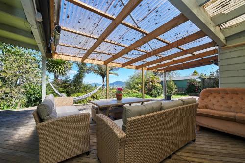 a patio with a wooden pergola and chairs and a table at Luigi's apartment in Rotorua