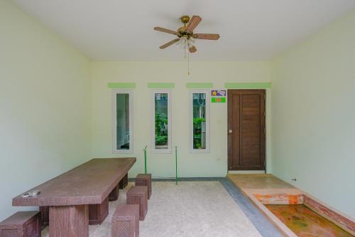 a room with a wooden table and a ceiling fan at Baan Noppadol Hua Hin Resort in Hua Hin