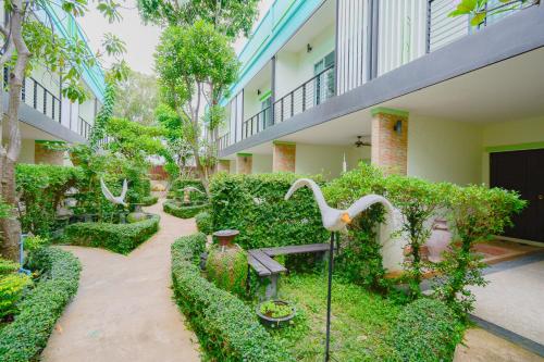 a garden with a bird statue in the middle of a building at Baan Noppadol Hua Hin Resort in Hua Hin