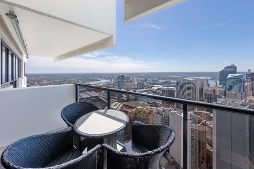 a balcony with a table and chairs on a building at Meriton Suites Kent Street, Sydney in Sydney