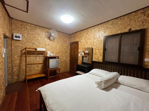 een slaapkamer met een wit bed en een tv bij Nadoiview Homestay นาดอยวิวโฮมสเตย์ in Pua