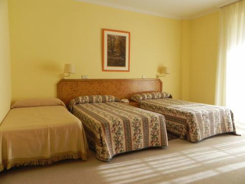 a hotel room with two beds and a window at Toros de Guisando in El Tiemblo