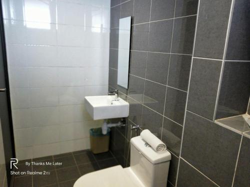 ein Badezimmer mit einem WC, einem Waschbecken und einem Spiegel in der Unterkunft The Leverage Lite (Kuantan) in Kuantan
