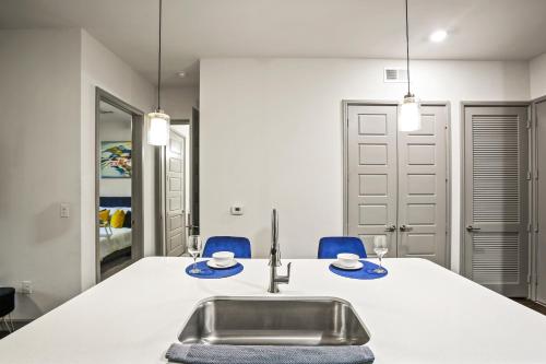 a kitchen with a sink and blue chairs at Luxury Apartment Close to Everything w Free Parking 5 in Houston