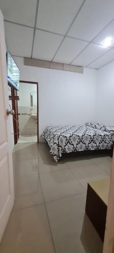 1 dormitorio con 1 cama con manta blanca y negra en SUITES FAMILIAR, en Guayaquil