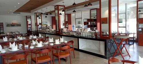 een restaurant met een lange bar met oranje stoelen bij V V Hotel Battambang in Battambang