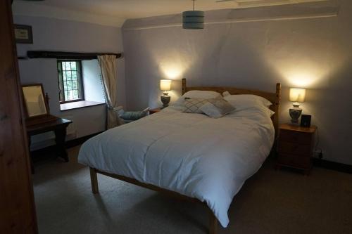 a bedroom with a large white bed with two lamps at Stunning Historic 2-Bed House in Shaftesbury in Shaftesbury