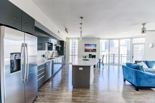 a kitchen with a refrigerator and a blue couch at Uptown Charlotte 2BR Furnished Apartments apts in Charlotte