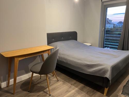 een slaapkamer met een bed, een bureau en een stoel bij Dom Villa Forest z dwupoziomowym 120 m apartamentem in Kuźnia Raciborska