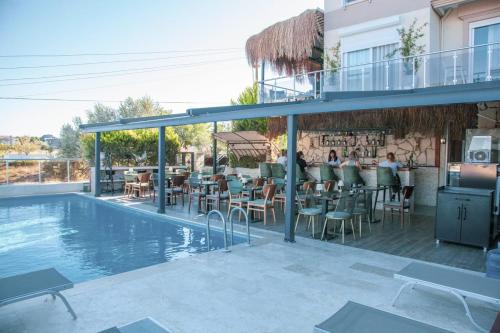 a resort with a swimming pool and a restaurant at Aden Boutique Otel in Çeşme