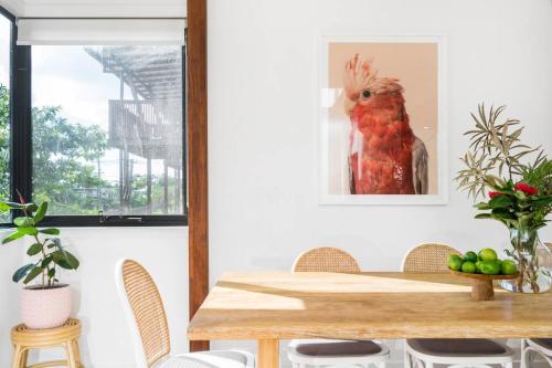 a dining room with a table with a bird on the wall at Canopy II - Beach House in the heart of Byron Bay in Byron Bay