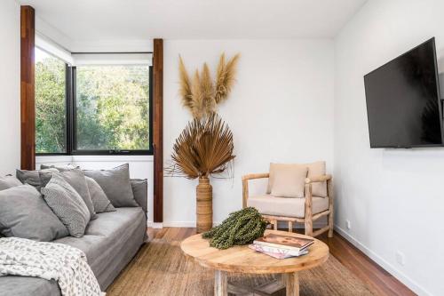 a living room with a couch and a table at Canopy II - Beach House in the heart of Byron Bay in Byron Bay