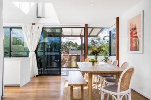 a kitchen and dining room with a table and chairs at Canopy II - Beach House in the heart of Byron Bay in Byron Bay