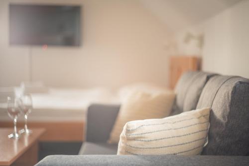 a living room with a gray couch with a throw pillow at Penzion Horska Kvilda in Horská Kvilda