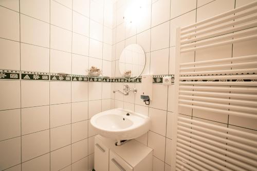 a white bathroom with a sink and a mirror at Penzion Horska Kvilda in Horská Kvilda