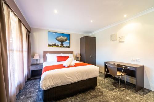 1 dormitorio con 1 cama, escritorio y 1 cama en Parkes International en Parkes