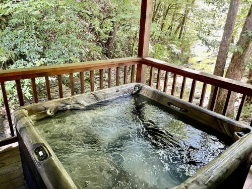 a hot tub on the deck of a porch at Creekside cabin in Townsend