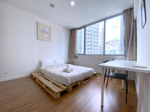 1 dormitorio con cama, mesa y ventana en Mercu Summer Suites Bernice KLCC, en Kuala Lumpur