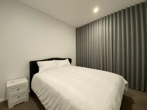 a bedroom with a white bed and a window at Luxury Disney 3 BR Apt- Pool-Gym-Sauna-Steam Room in Adelaide