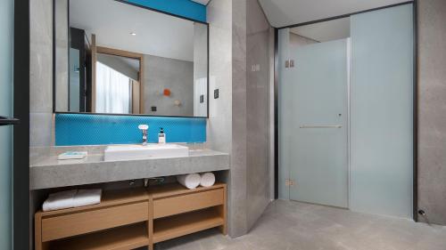 ein Bad mit einem Waschbecken und einem Spiegel in der Unterkunft Holiday Inn Express Xi'an Qujiang Center, an IHG Hotel in Xi'an