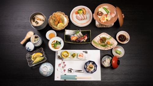 una tavola ricoperta di piatti e ciotole di cibo di Saigiku a Iwaki
