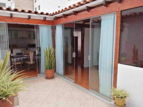 an open patio with glass doors and potted plants at APARTMENT IN MIRAFLORES in Lima