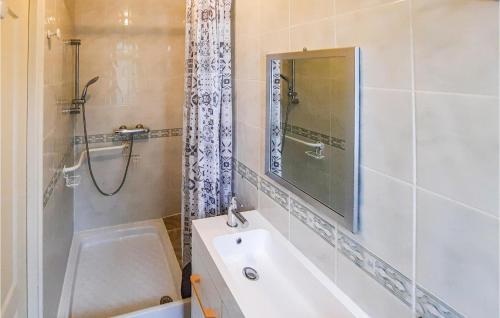 een badkamer met een bad, een wastafel en een douche bij 2 Bedroom Stunning Home In Bannalec in Bannalec