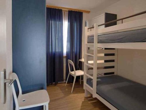 Cette chambre comprend deux lits superposés et un bureau. dans l'établissement Ferienwohnung Profos 54002B, à Ruschein