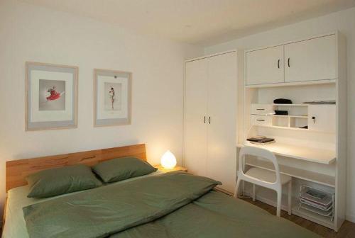 Habitación blanca con cama y escritorio en Ferienwohnung Profos 54002B en Ruschein