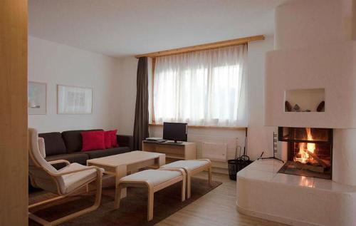 sala de estar con sofá y chimenea en Ferienwohnung Profos 54002B en Ruschein