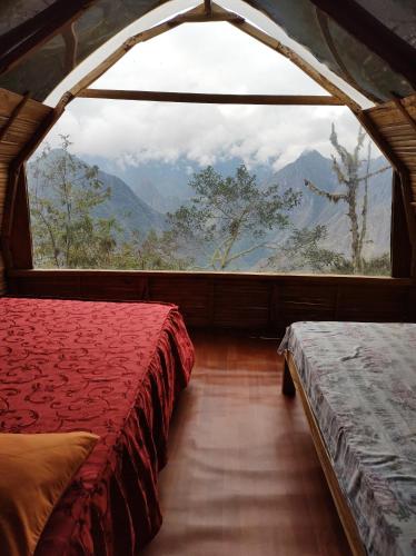 a room with two beds and a large window at Machupicchu EcoLodge in Cusco