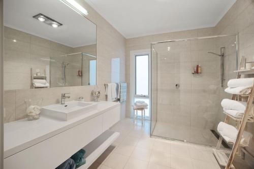 uma casa de banho branca com um lavatório e um chuveiro em Live the Luxury Lifestyle in Lohr em Inverloch