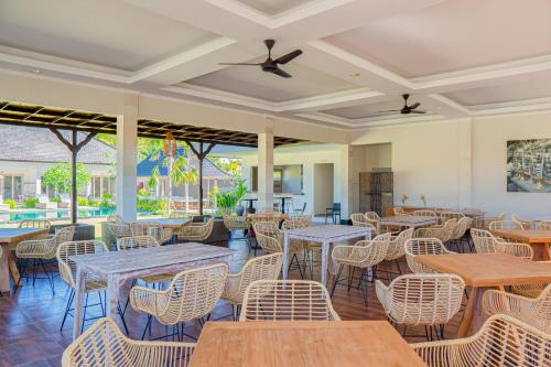 a restaurant with tables and chairs and a patio at Green D'Mel Luxury Homestay in Nusa Dua