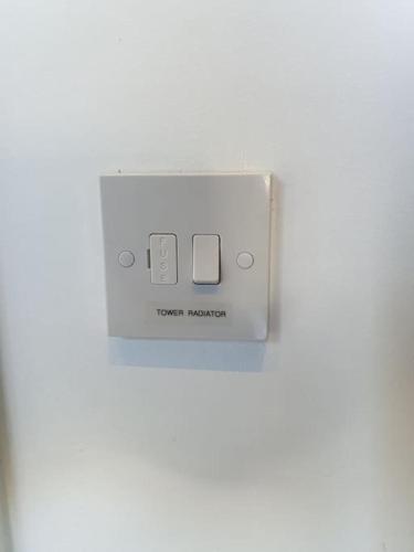 a white lightswitch sitting on a white table at The Tiny Sea Gem in Jaywick Sands