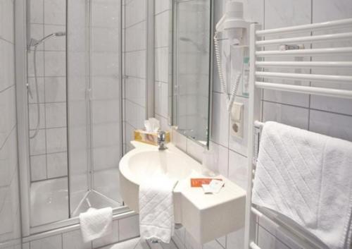 Hotel Bären في فيلينغن شفيننغن: حمام أبيض مع حوض ودش
