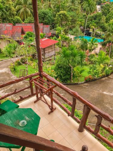 a balcony with a bench and a view of a park at Tanouy Garden in Baan Khai