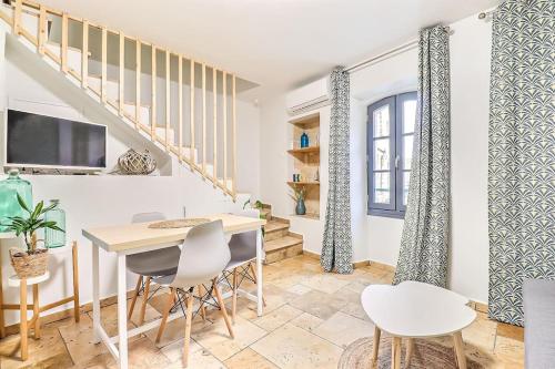 a living room with a table and chairs and a staircase at LA MAISON FAYARD - 3 pers - Centre Clim Wifi Cosy Garage in Saint-Gilles