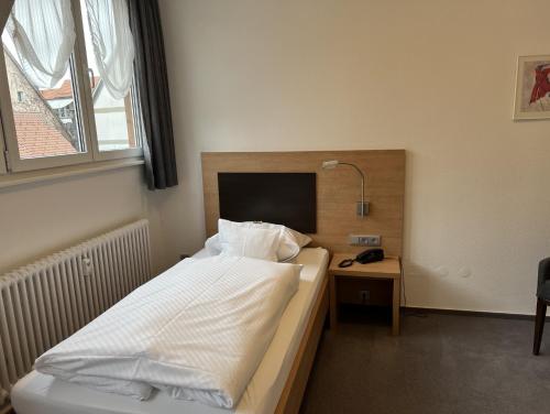 a bedroom with a bed and a desk with a lamp at Hotel Bären in Villingen-Schwenningen