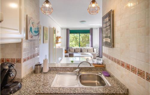 eine Küche mit einem Waschbecken und ein Wohnzimmer in der Unterkunft Lovely Apartment In Orihuela With Swimming Pool in Orihuela