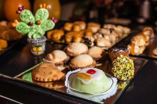 uma bandeja cheia de diferentes tipos de bolos e biscoitos em Central Gallery Rooms- Palazzo D'Ali' Staiti XIX em Trapani