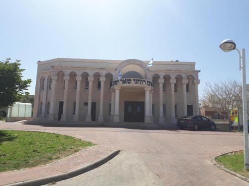 a large building with a sign on the front of it at Sitrin apartment Leonardo Hotel Area Ashdod in Ashdod
