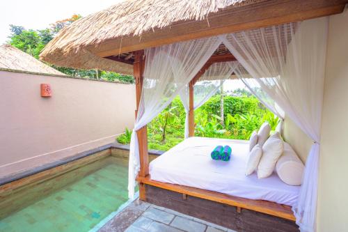 a bedroom with a bed and a swimming pool at Alam Puisi Villa Ubud in Ubud