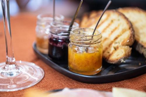a plate of food with jams and bread on a table at Central Gallery Rooms- Palazzo D'Ali' Staiti XIX in Trapani
