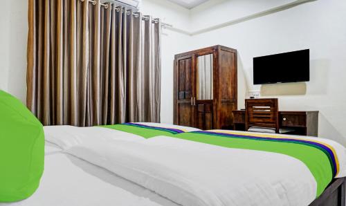 a bedroom with a bed and a desk and a television at Treebo Tulip in Pune