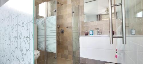 a bathroom with a shower and a sink and a toilet at Sitrin apartment Leonardo Hotel Area Ashdod in Ashdod