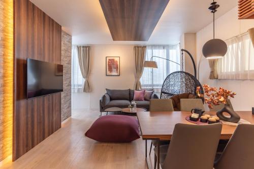 a living room with a table and a dining room at Bijou Suites Sorriso in Osaka