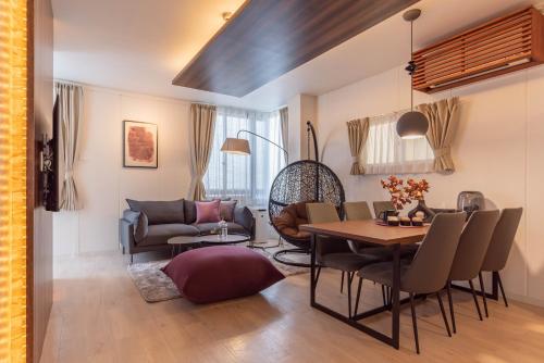 a living room with a table and a couch at Bijou Suites Sorriso in Osaka